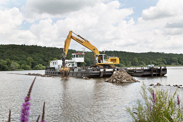 hydraulik-schwimmbagger vom Ufer